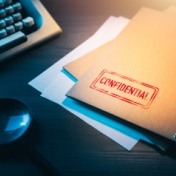 paper files on desk that read confidential